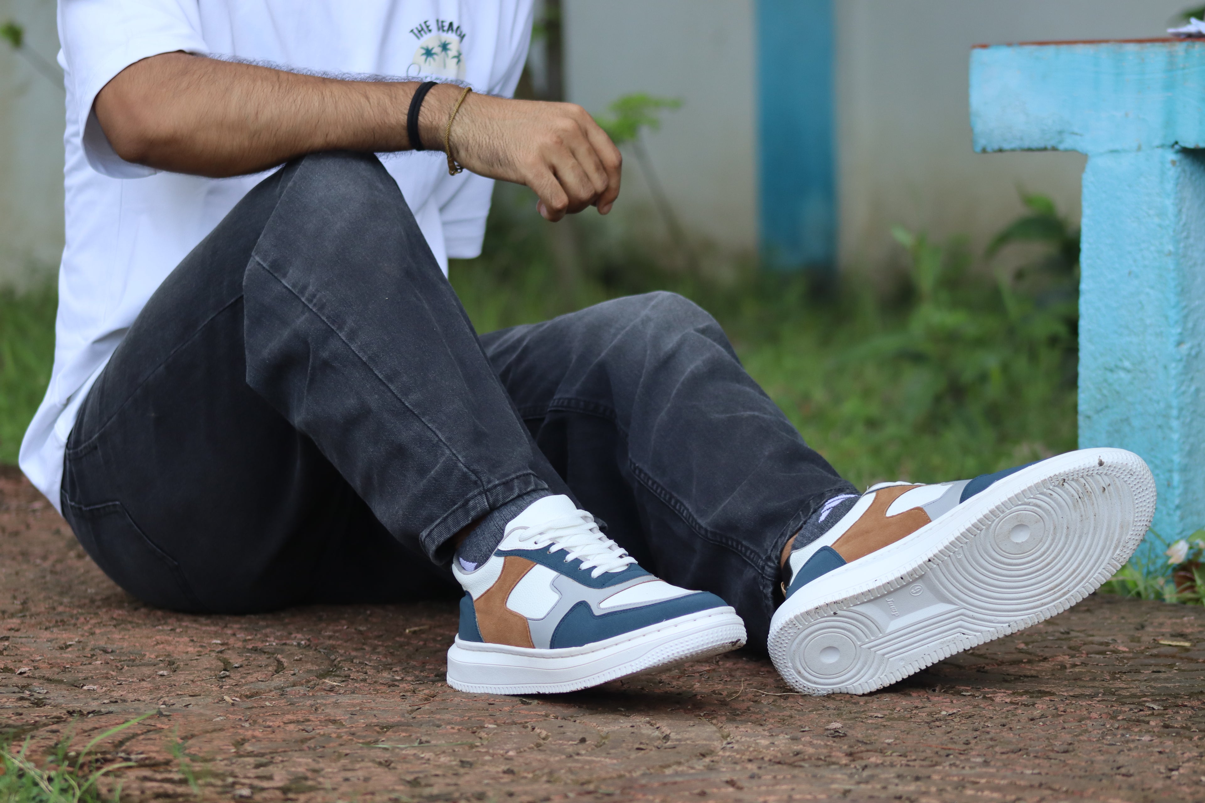 Person wearing patterned sneakers sitting outdoors with a blurred background